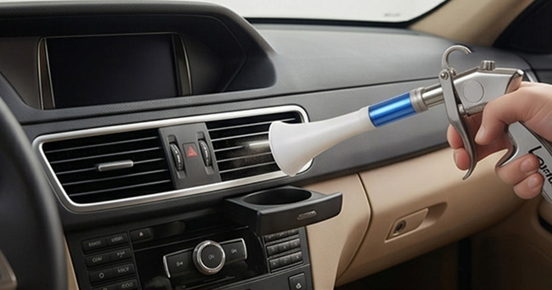 Using a Le Lematec safety air blow gun to clean dust from a vehicle dashboard interior.
