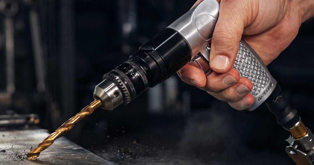Close-up of a hand using a Le Lematec pneumatic air drill with a gold-colored drill bit on a piece of metal.