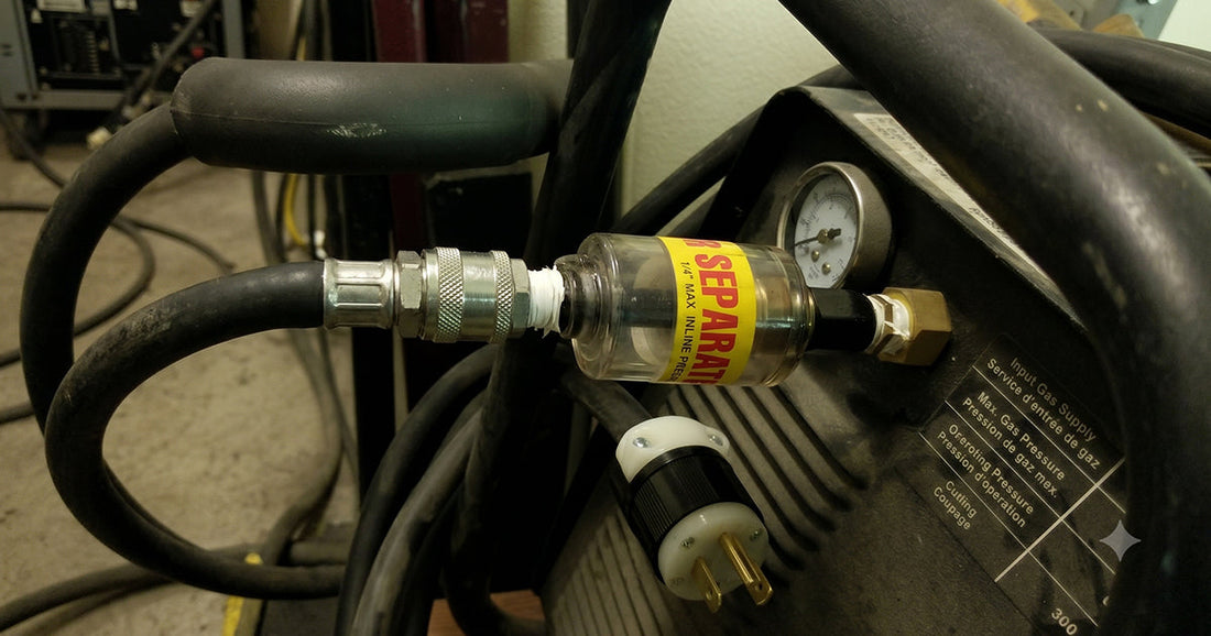 Close-up of an inline air separator filter installed on an air compressor hose line to remove moisture.